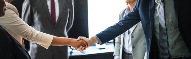 business owners shaking hands during sales training program