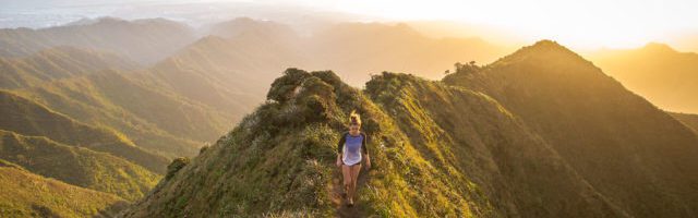 woman climbing a mountain after completing her online sales training program